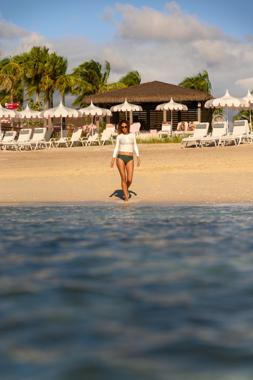 Celebration Key for Princess: a guest walking out of the water toward the Pearl Cove beach
